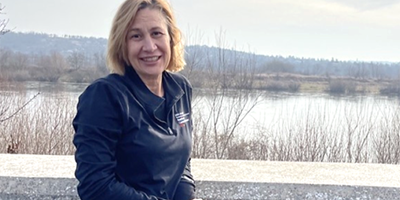 Dr. Candace TenBrink at the Dniester River with the hills of Ukraine behind her.