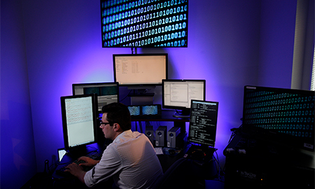 Man at desk with multiple screens