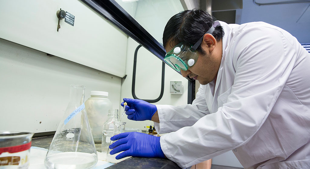 Lab tech adding sample to a container.