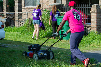 Students mowing and collecting trash