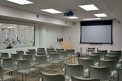 Event room with chairs lined up in rows in front of a projector and podium